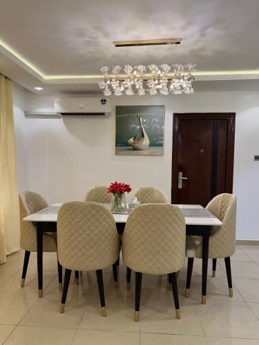 jadalnia ze stołem, krzesłami i żyrandolem w obiekcie First Alive Home w mieście Lekki