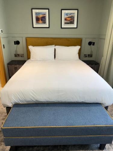 a large white bed with a blue foot board at Oban House House in Oban