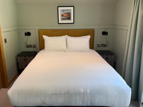 a bed with white sheets and pillows in a bedroom at Oban House House in Oban