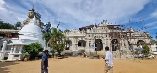 two men standing in front of a building with a statue at gibt nicht in Nikawatawana