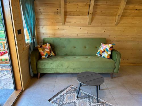 a green couch in a room with a table at Koliba Vilin Konak in Blaca