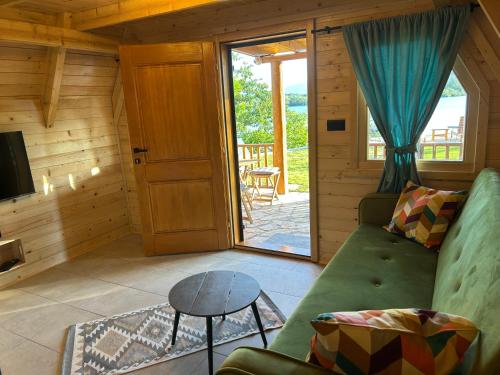 a living room with a green couch and a sliding glass door at Koliba Vilin Konak in Blaca
