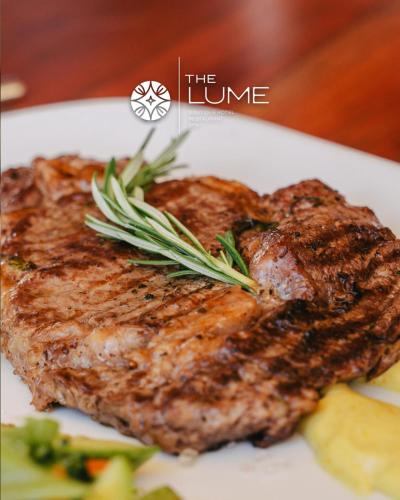 a piece of steak on a white plate with vegetables at The Lume Boutique Hotel & Restaurant & Spa in Bodrum City