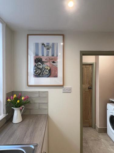 a kitchen with a picture on the wall at Stylish Seaside Home with Garden 2 minutes to Beach in Margate
