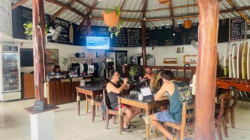 a group of people sitting at tables in a restaurant at La Posada - Hostel in Santa Teresa Beach