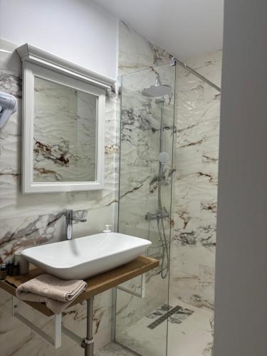 a bathroom with a sink and a glass shower at Casa Seren in Corabia