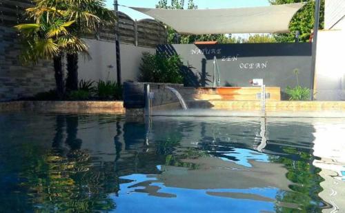 - une piscine avec une fontaine dans l'eau dans l'établissement Camping 4 étoiles - Piscine - cbgcaig, à Notre-Dame-de-Monts