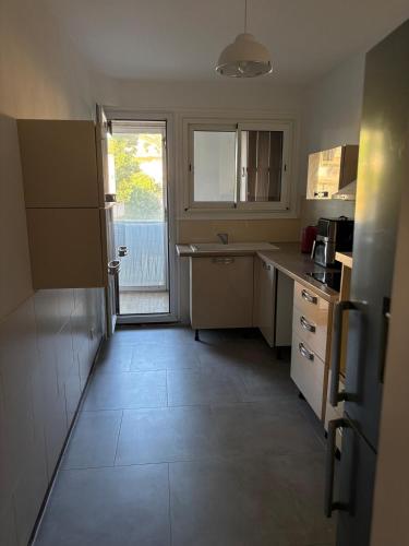 une petite cuisine avec un évier et un comptoir dans l'établissement Logement calme et spacieux, à Marseille