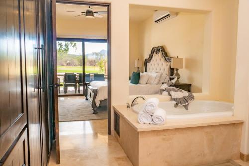 Un baño con bañera y un dormitorio con cama. en Los Cabos Golf Resort, Trademark Collection by Wyndham, en Cabo San Lucas