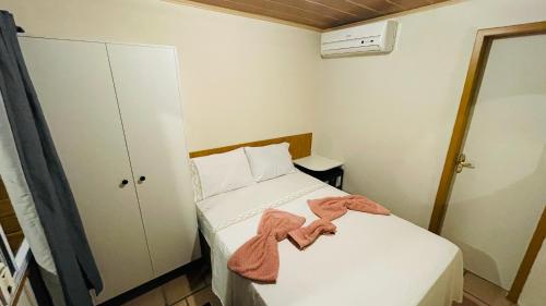 a small bedroom with a bed with towels on it at Pousada Cair do Sol in Ilha do Mel