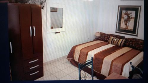a bedroom with a bed and a dresser in it at Chez Lilly in Oranjestad