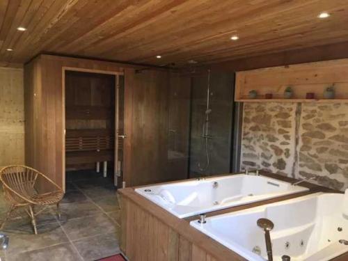 La grande salle de bains est pourvue d'une baignoire et d'une chaise. dans l'établissement Camping 4 étoiles - Piscine - eeciaf, à Meyronne