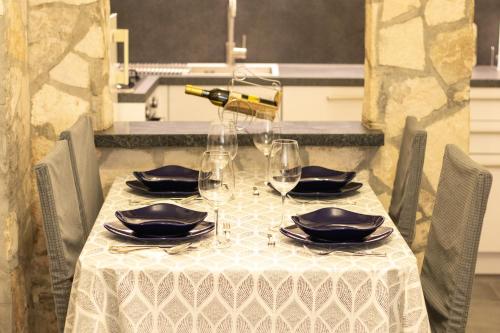 a table with a white table cloth and wine glasses at Apartment Trsina in Rakalj