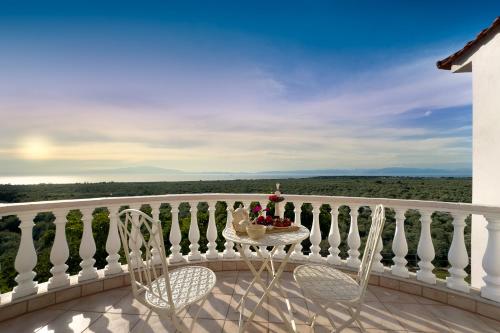 a table and chairs on a balcony with a view at Villa Mitsekou in Prinos
