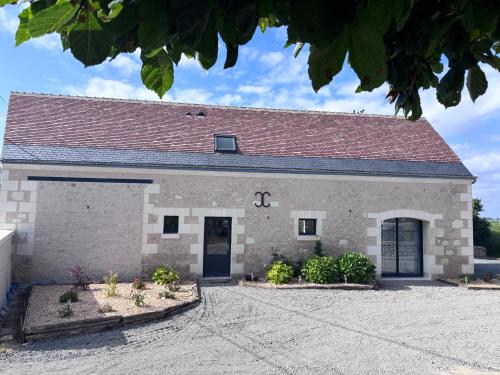 a large stone building with a red roof at Gîte La Marnière in Luzillé