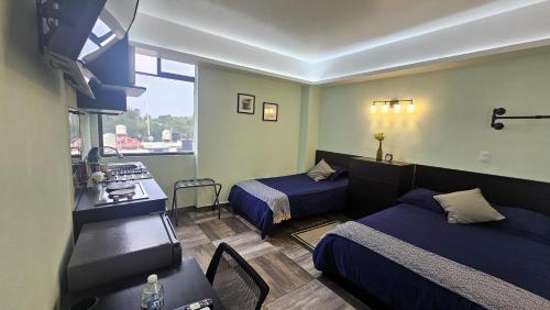 a hotel room with two beds and a kitchen at A21 SUITE BLACK MAX para 1 a 4 personas, Especialistas en CORTAS, MEDIANAS Y LARGAS ESTANCIAS en IZCALLI TEPOTZOTLAN perfecto para Familias, Turistas, Contratistas, Estudiantes, Empresas A sólo 5 min Izcalli 5 min Esmeralda 20 min Satélite 25 min AIFA in Cuautitlán Izcalli