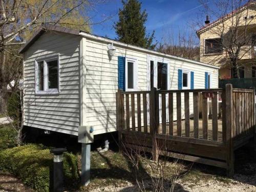 una piccola casa bianca con una recinzione in legno di Camping 3 étoiles - ccbbbda a Castellane