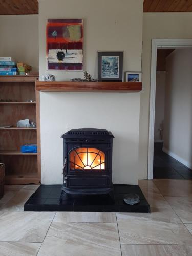 a stove with a fire inside of a room at Teach Chnoc na hEorna in Goleen