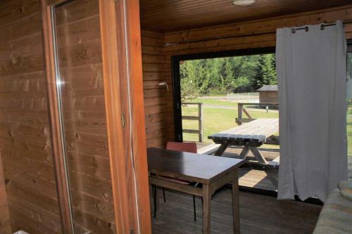 - une véranda avec une table et une table de pique-nique dans l'établissement Chalet 3 étoiles - Piscine - eeid0f, à Corrèze