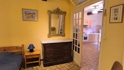 - une chambre avec un miroir, une commode et un lit dans l'établissement Petit appartement au cœur du centre historique de Collioure, à Collioure