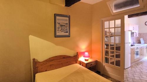 une chambre avec un lit et une table avec une lampe dans l'établissement Petit appartement au cœur du centre historique de Collioure, à Collioure