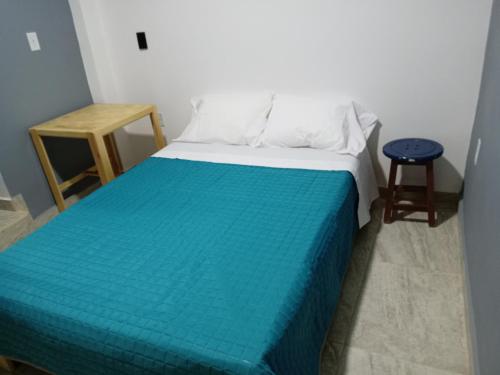 a bedroom with a bed with a blue blanket and a stool at Casa Naty in Mexico City
