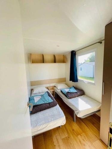 deux lits dans une petite pièce avec une fenêtre dans l'établissement Camping 3 étoiles - Piscine - efb0gh, à Erquy