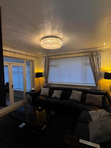a living room with a couch and a chandelier at 230 Councillor Lane in Cheadle