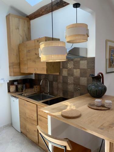 - une cuisine avec une table en bois et un évier dans l'établissement Maisonnette de charme 60m2, à Robion