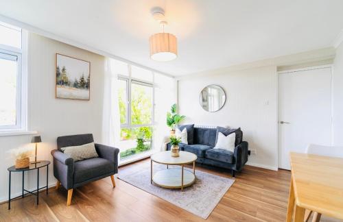 a living room with two chairs and a table at Sleek 2 Bedroom Apartment in Belfast