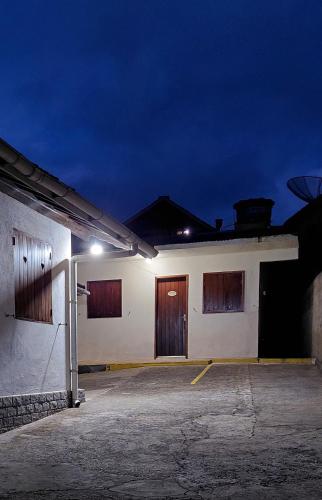a white building with brown doors in a parking lot at Apartamentos Roncalli Monte Verde in Monte Verde