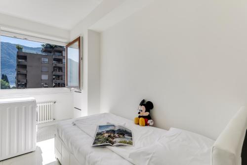 a white bedroom with a bed and a window at Paradiso Incanto - Happy Rentals in Paradiso