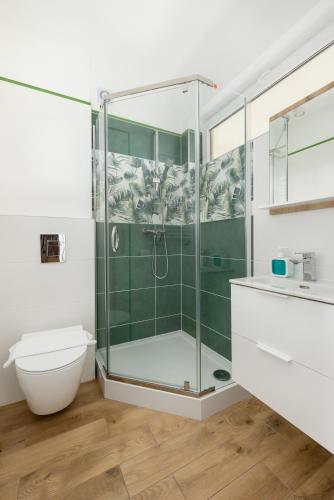 a bathroom with a glass shower and a toilet at Dom Wczasowy Radość in Rewal
