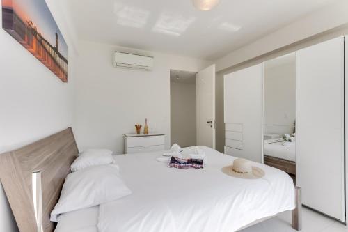 a white bedroom with a bed and a mirror at Paradiso Incanto - Happy Rentals in Paradiso