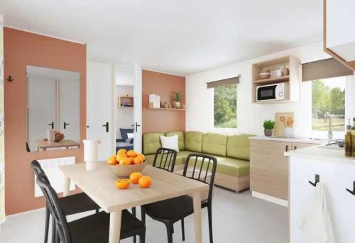 a kitchen and living room with a table with oranges on it at Camping 3 étoiles - ccaiaah in Monoblet