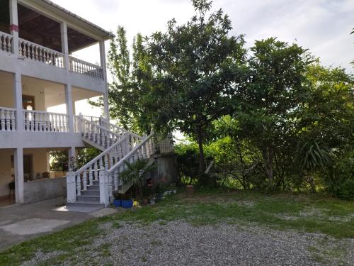 a house with a staircase and trees in the yard at Guest house maka in Gonio