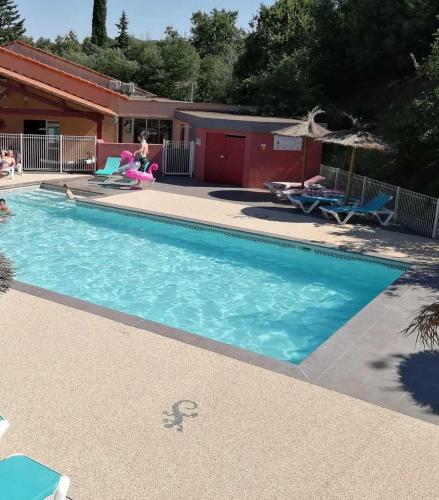 une piscine avec de l'eau bleue dans une cour dans l'établissement Camping 3 étoiles - Piscine - eecbhg, au Boulou