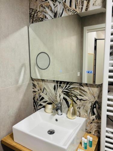 a bathroom with a sink and a mirror at Golden House by ApartSuite in Chioggia
