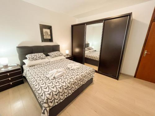a bedroom with a bed and a large mirror at Apartment Trsina in Rakalj