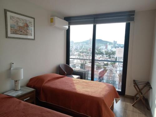 Una habitación de hotel con dos camas y una gran ventana. en Luxury, security, infinity pool, view, centric, en Miravalle