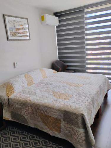 a bedroom with a bed and a chair and a window at Luxury, security, infinity pool, view, centric in Miravalle