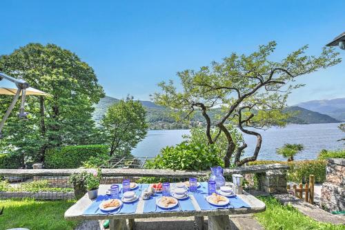 a picnic table with food and a view of a lake at Mica Aurea Morcote - Happy Rentals in Morcote