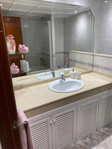 a bathroom with a sink and a large mirror at Apartamento Marisol in Alcañiz
