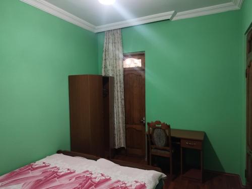 a bedroom with a bed and a desk and a window at Guest house maka in Gonio