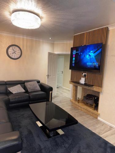 a living room with a couch and a flat screen tv at 230 Councillor Lane in Cheadle