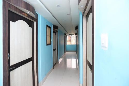 a hallway with blue walls and a door at Hotel O Mega Palace in Patna