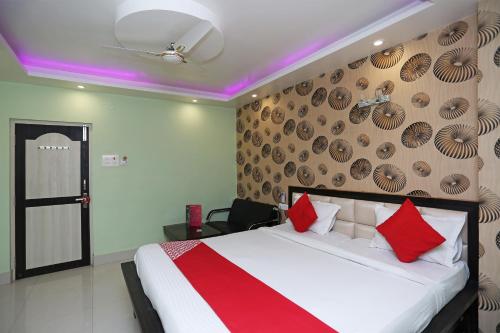 a bedroom with a large bed with red pillows at Hotel O Mega Palace in Patna