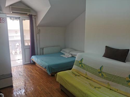 a bedroom with two beds and a couch in it at Stars Aspava Blue HOSTEL in Podgorica