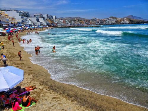 a group of people on a beach with the ocean at Condominio Ocean reef in San Bartolo
