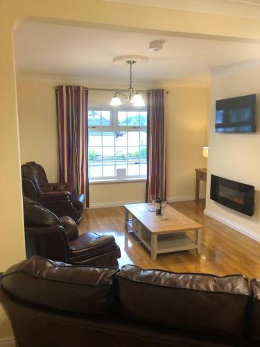 a living room with two leather chairs and a coffee table at Lake View Retreat in Enniskillen